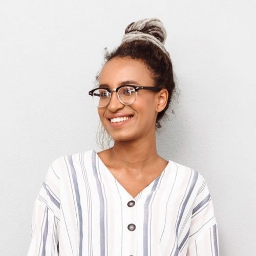 cheerful-smiling-young-african-business-woman-with-dreads-isolated-over-white-wall-background--e1626782462952.jpg